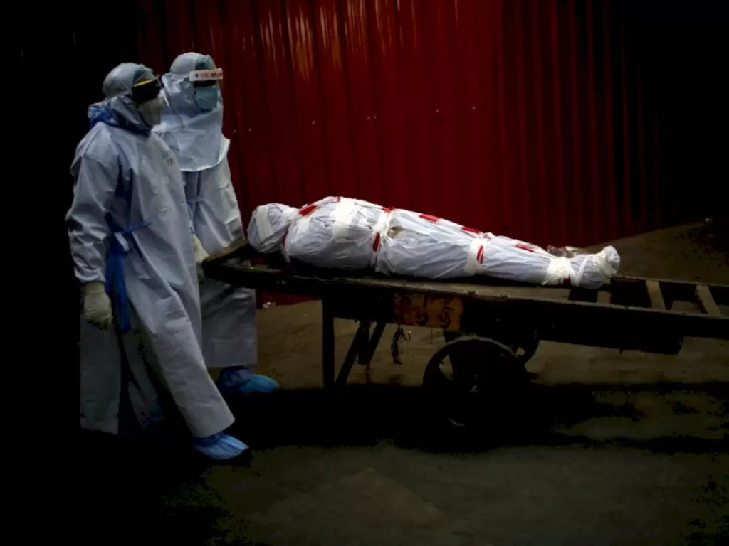 Petugas kesehatan membawa jenazah korban Covid-19 di India untuk dikremasi. (REUTERS/Adnan Abidi)