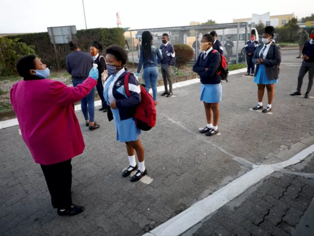 Sejumlah siswa di Afrika Selatan sedang diperiksa cek suhu tubuhnya. (REUTERS/Mike Hutchings)