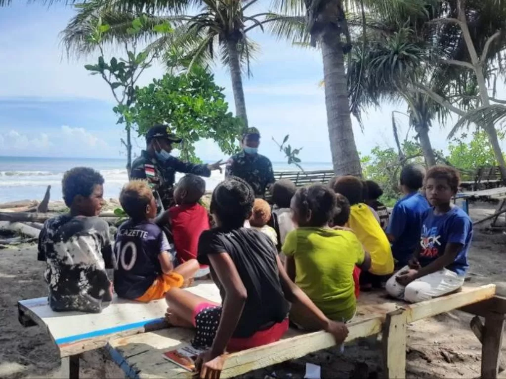  Personel Satgas Yonif MR 413 Kostrad Serda Dani sedang mengajarkan wawasan kebangsaan kepada anak-anak di perbatasan RI-PNG dengan cara belajar di Pantai Skouw Mabo. (ANTARA News Papua/HO-Pendam XVII/Cenderawasih) 