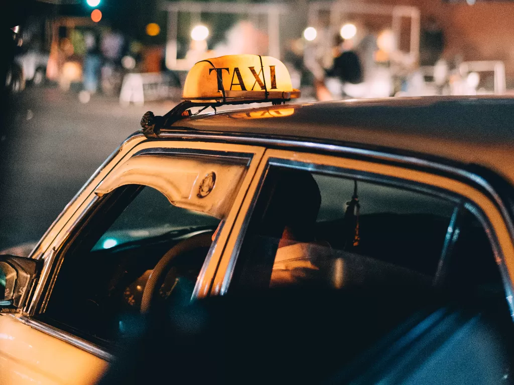 Ilustrasi naik taksi malam hari. (Unsplash/@mougrapher)
