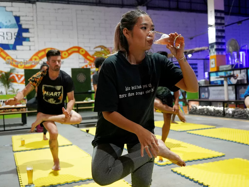 Warga Kamboja minum bir sambil yoga (REUTERS/Cindy Liu)