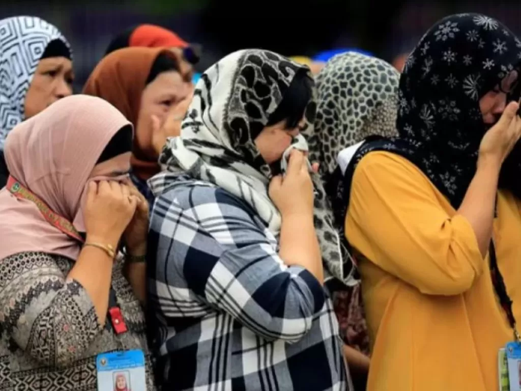  Sukarelawan menghapus air mata mereka saat mereka mengingat prajurit dan penduduk sipil yang tewas dalam penyerangan pasukan pemerintah terhadap pemberontak dari kelompok Maute, yang mengambil alih sebagian besar kota Marawi, dalam upacara penaikan bende