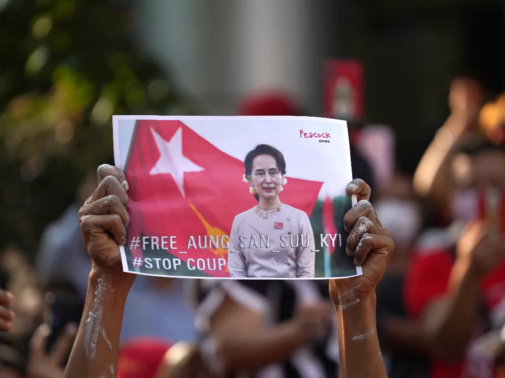Pengunjuk rasa Myanmar yang tinggal di Jepang membawa foto Aung San Suu Kyi saat mereka melakukan protes terhadap militer Myanmar di Bangkok, Thailand. Senin (1/2/2021). (photo/REUTERS/Athit Perawongmetha)