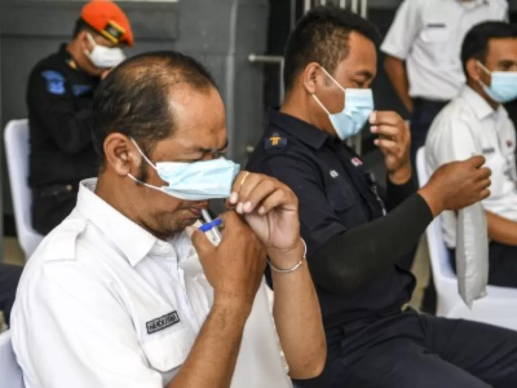 Pegawai PT KAI (persero) menghembuskan nafasnya pada kantong nafas untuk dites dengan GeNose C19 di Stasiun Pasar Senen, Jakarta, Sabtu (23/1/2021). (ANTARA FOTO/M Risyal Hidayat)