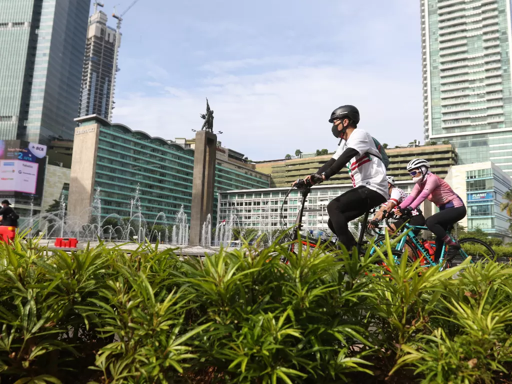Warga bersepeda melintasi kawasan Bundaran HI, Jakarta. (photo/ANTARA FOTO/Reno Esnir)