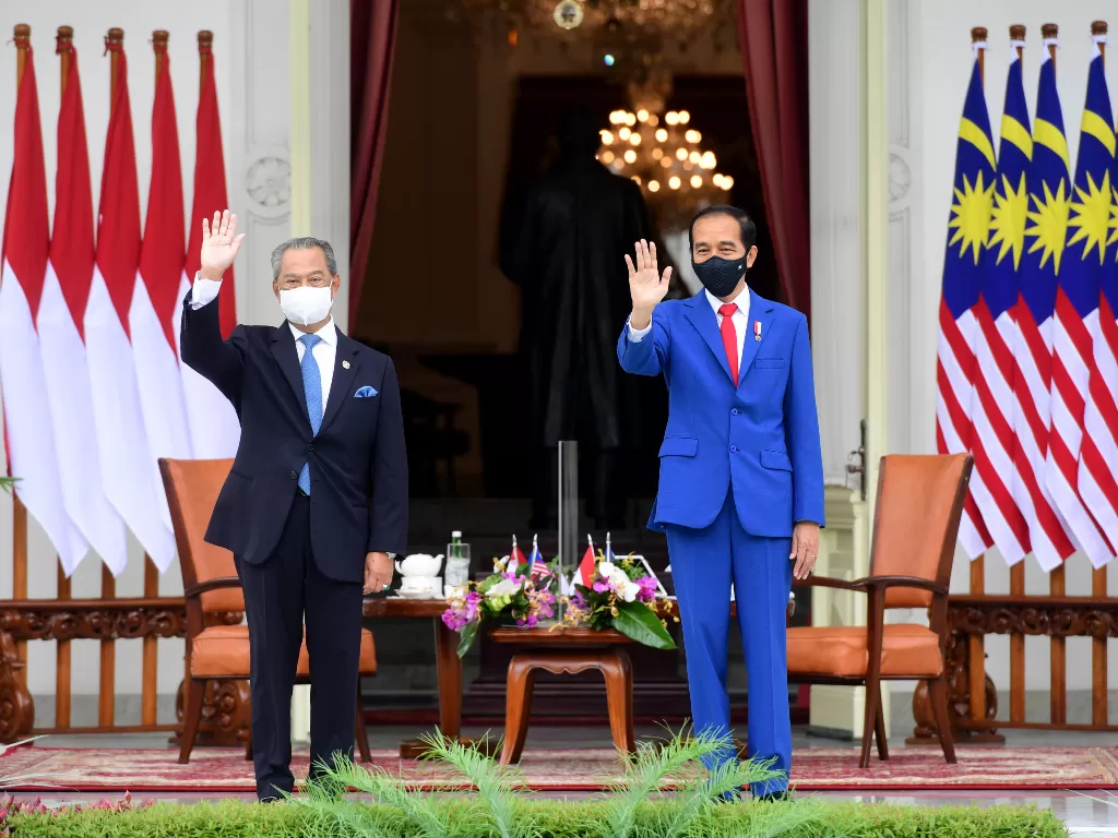 Presiden Joko Widodo (kanan) bersama Perdana Menteri Malaysia Muhyiddin Yassin (kiri) melambaikan tangan di veranda Istana Merdeka, Jakarta, Jumat (5/2/2021).  (photo/ANTARA FOTO/Setpres/Laily Rachev)