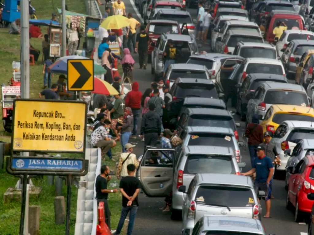 Sejumlah wisatawan keluar dari kendaraanya menunggu kemacetan reda akibat buka tutup jalan Puncak, Gadog, Kabupaten Bogor, Jawa Barat, Minggu (16/8/2020). (ANTARA FOTO/Yulius Satria Wijaya)
