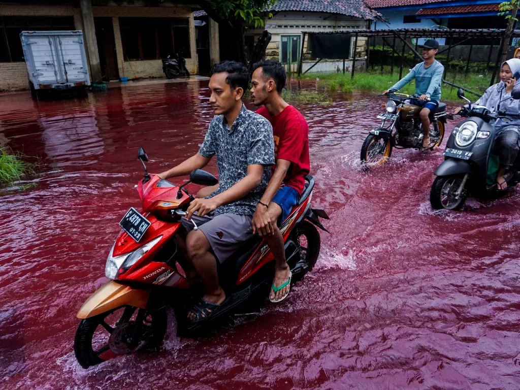 Jalan perkampungan yang tergenang banjir berwarna merah di Jenggot, Pekalongan, Jawa Tengah, Sabtu (6/2/2021). (photo/ANTARA FOTO/Harviyan Perdana Putra)