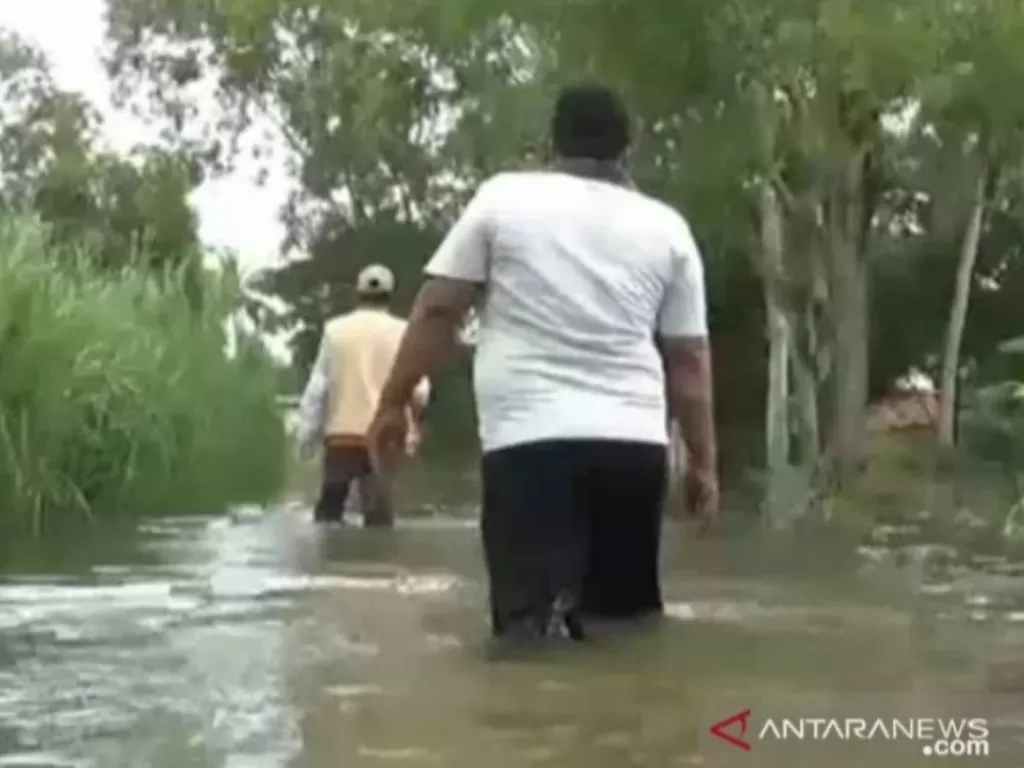 Warga Desa Pantai Harapan Jaya, Kecamatan Muaragembong, Kabupaten Bekasi, Jawa Barat, Sabtu (6/2/2021) memantau kondisi banjir yang belum juga surut sejak tiga hari terakhir. ANTARA/Pradita Kurniawan Syah.