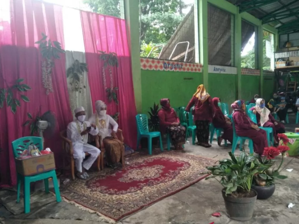 Mempelai berpose di depan keluarga saat menggelar resepsi pernikahan di Depo Pengolahan Sampah Duren Sawit, Jakarta Timur, Rabu (10/2/202). (ANTARA/Andi Firdaus).