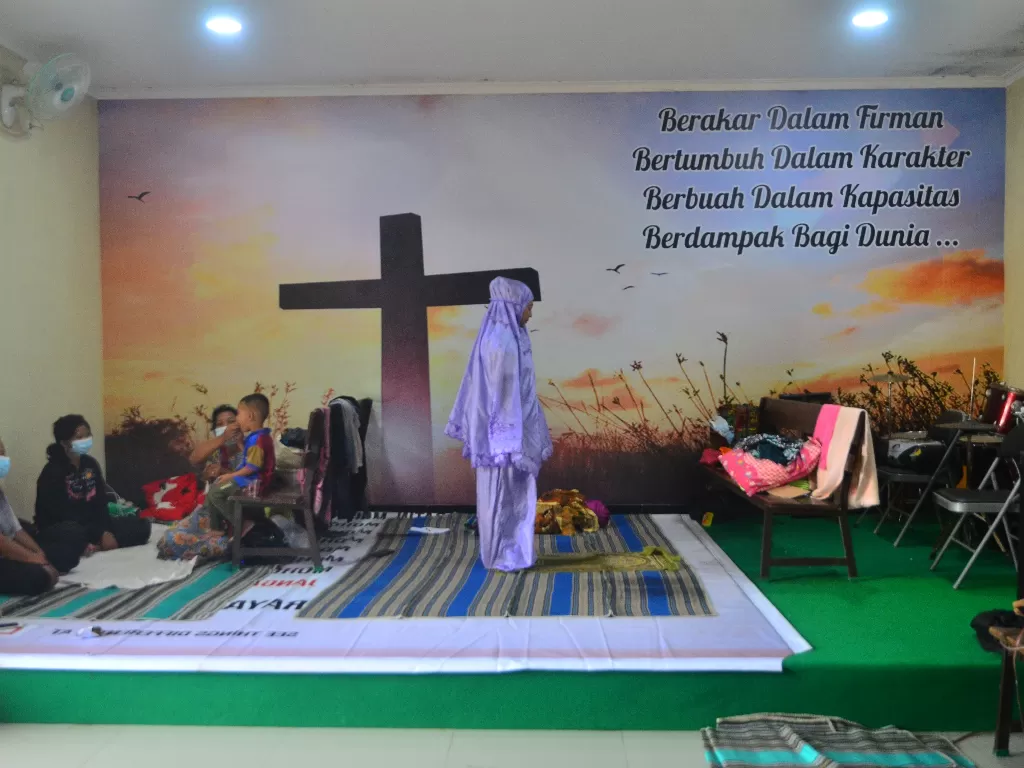 Pengungsi korban banjir melakukan shalat di ruang aula Gereja Kristen Muria Indonesia (GKMI) Tanjung Karang, Kudus, Jawa Tengah, Kamis (11/2/2021).  (photo/ANTARA FOTO/Yusuf Nugroho)