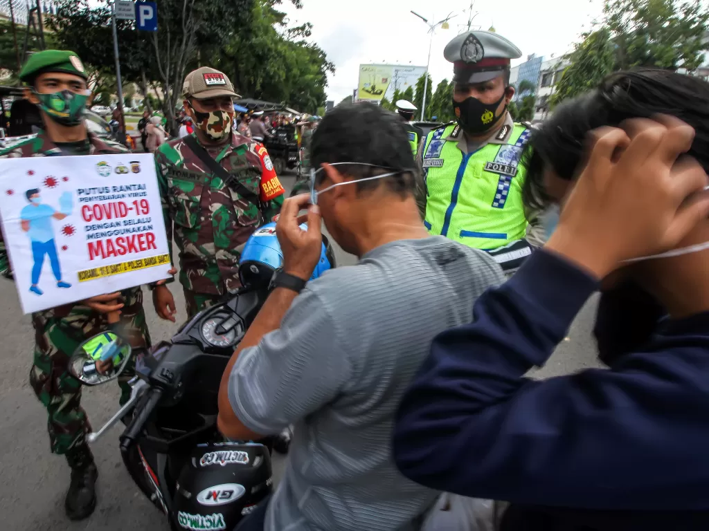 Petugas menindak masyarakat di Aceh karena melanggar prokes. (photo/ANTARA FOTO/Rahmad)