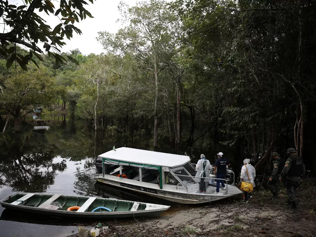 Petugas kesehatan dan polisi militer lingkungan meninggalkan Cagar Pembangunan Berkelanjutan Tupe setelah memberikan vaksin AstraZeneca di wilahyah Amazon, Brasil (9/2/2021).  (REUTERS/Bruno Kelly)