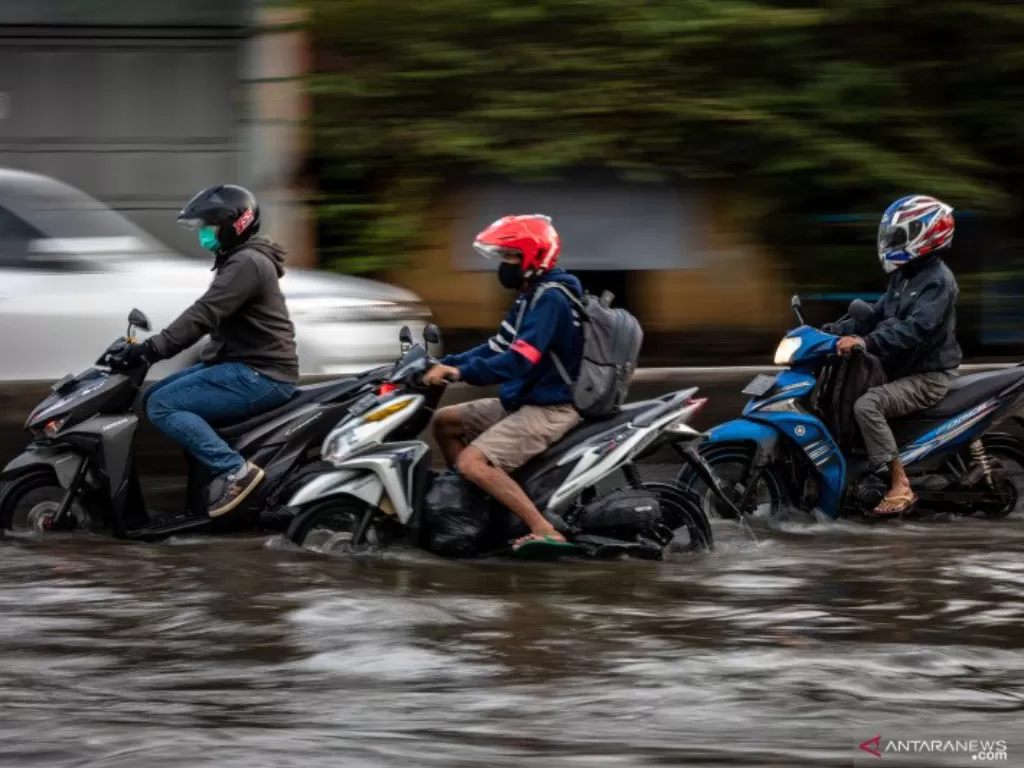 Pengendara menembus banjir yang merendam jalur Pantura Jalan Raya Kaligawe KM 7 di Genuk, Semarang, Jawa Tengah, Jumat (12/2/2021). (ANTARA FOTO/Aji Styawan)