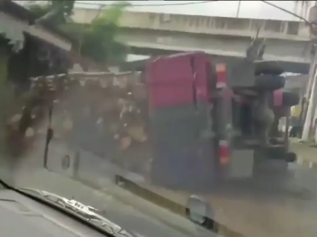 Truk pembawa kayu terguling di jalan (tangkapan layar)