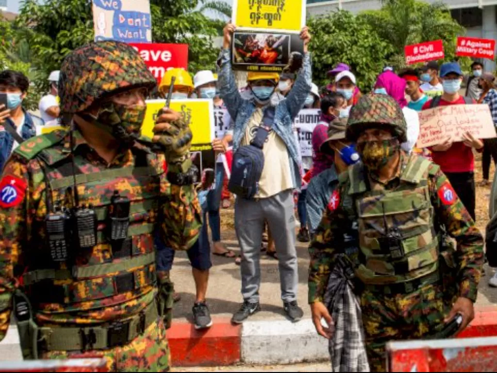 Militer Myanmar berdiri di luar Bank Sentral Myanmar selama protes terhadap kudeta militer, di Yangon, Myanmar. (REUTERS / Stringer)