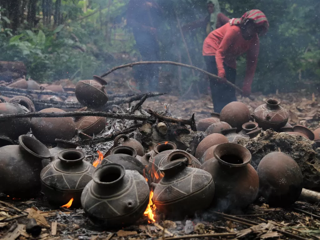 Perajin mengangkat gerabah yang selesai dibakar (ANTARA FOTO/Jojon)