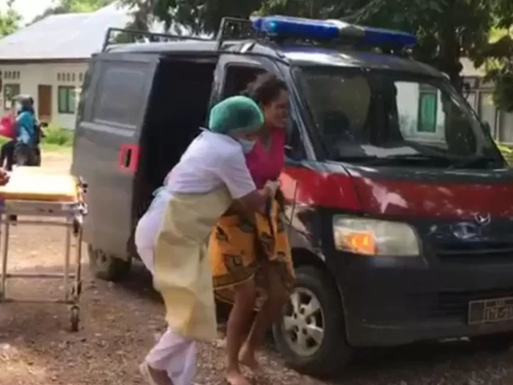 Seorang perawat memapah seorang ibu yang melahirkan di dalam kendaraan dinas Binmas Polres TTU (Antara)