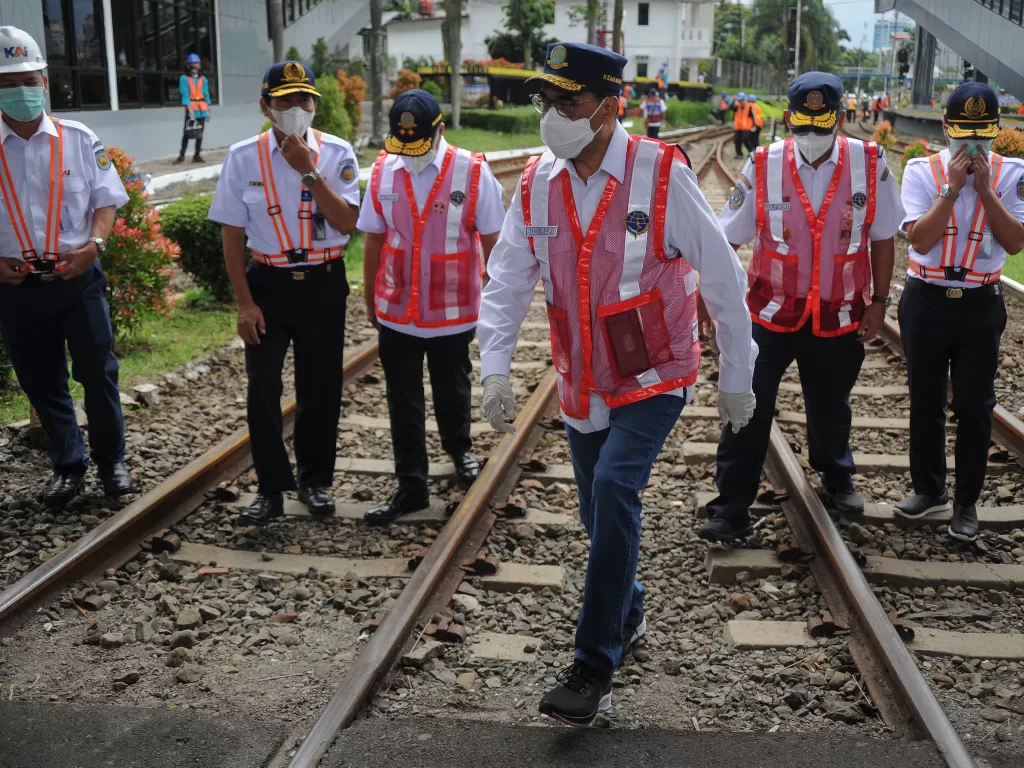 Menteri Perhubungan Budi Karya Sumadi (tengah) berjalan melintasi rel kereta api (ANTARA FOTO/Raisan Al Farisi)