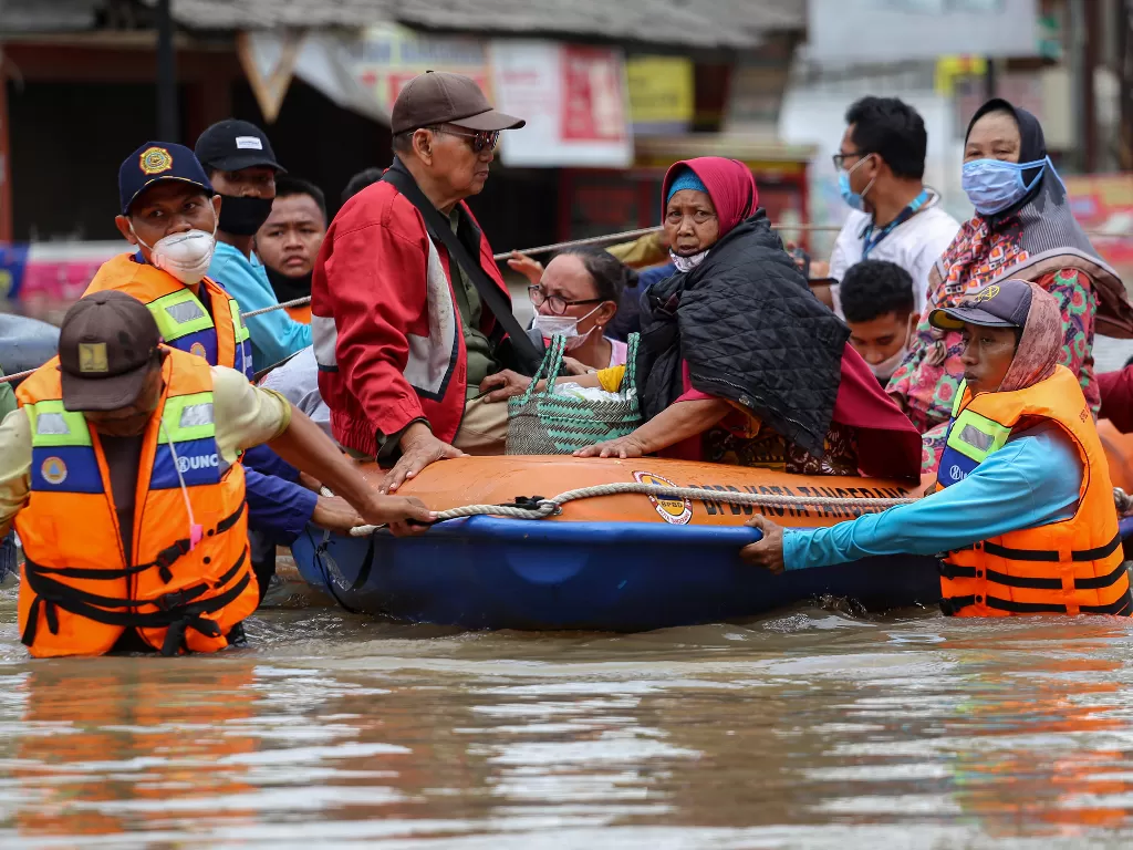 Petugas mengevakuasi warga menggunakan perahu karet saat banjir di Ciledug Indah, Kota Tangerang, Banten, Sabtu (20/2/2021). (Antara)