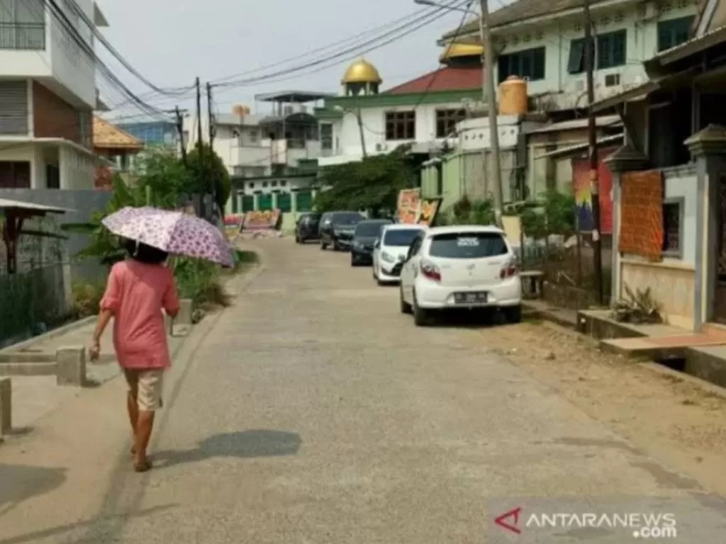 Ilustrasi - Seorang warga Kota Palembang menggunakan payung di siang hari akibat suhu udara ekstrem beberapa hari terkahir di Palembang, Senin (11/11/2019). (ANTARA/Aziz Munajar)