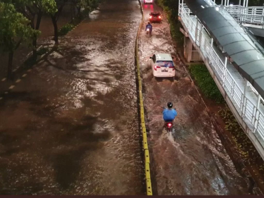 Pengendara melintas di dekat Halte Bus TransJakarta Cempaka Putih yang terendam banjir setinggi 40-50 sentimeter, Selasa (25/2/2020). (ANTARA/HO-PMJ)