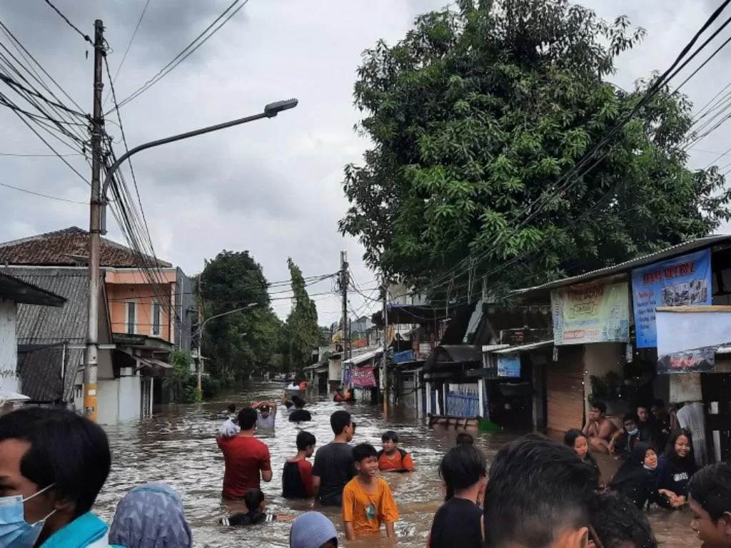 Warga melintas banjir yang menutup ruas jalan di Jalan Pondok Jaya, Kecamatan Mampang, Jakarta Selatan, Sabtu (20/2/2021). (ANTARA/Laily Rahmawaty)