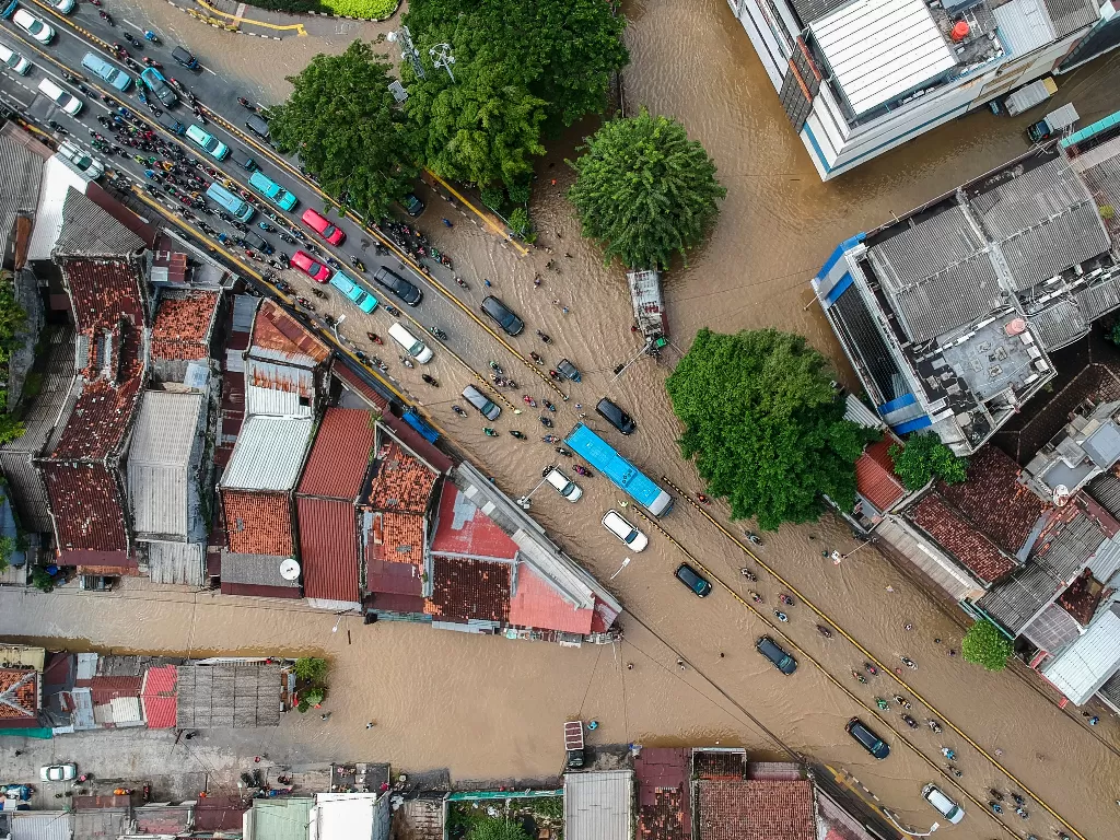 Foto aerial kendaraan melintasi banjir di Jalan Jatinegara Barat, Kampung Pulo, Jakarta, Senin (8/2/2021).  (photo/ANTARA FOTO/Galih Pradipta)