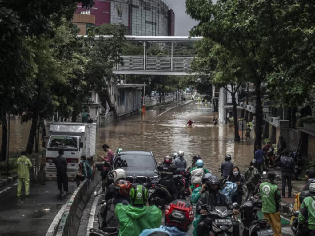 Sejumlah pengendara sepeda motor berhenti saat banjir di Jalan Warung Buncit Raya. (ANTARA FOTO/M Risyal Hidayat)