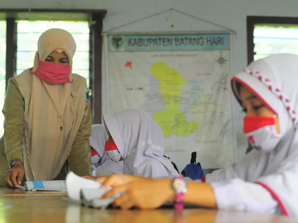 Guru memberikan materi pelajaran kepada siswa (ANTARA FOTO/Wahdi Septiawan)