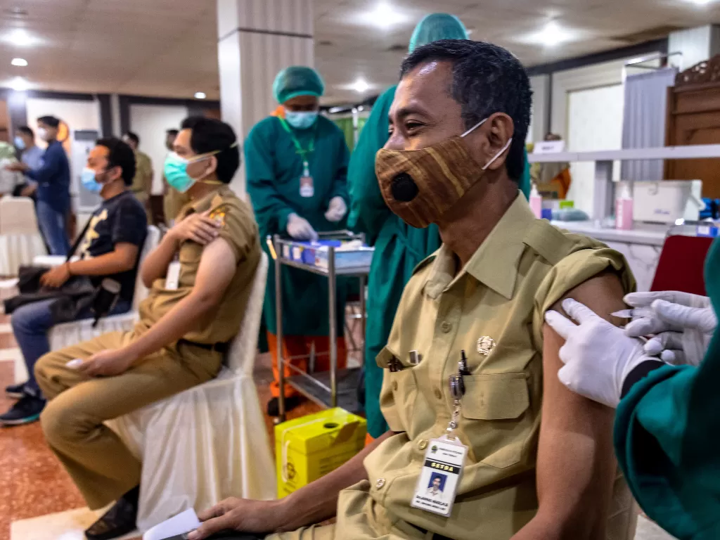 Vaksinator menyuntikkan vaksin Covid-19 Sinovac kepada petugas pelayanan publik Pemprov Jateng saat pelaksanaan vaksinasi gelombang II di Gedung Gradhika Bhakti Praja, Semarang, Jawa Tengah, Senin (22/2/2021). (ANTARA FOTO/Aji Styawan)