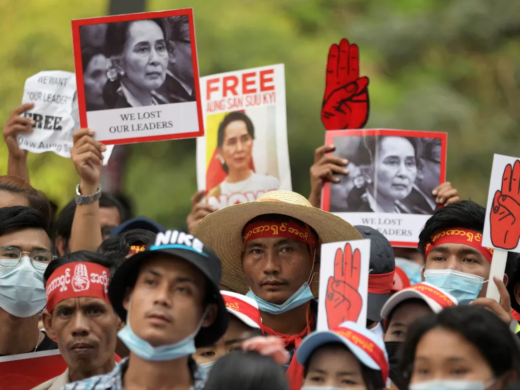 Para pengunjuk rasa memegang plakat bergambar Aung San Suu Kyi saat mereka memprotes kudeta militer di Yangon, Myanmar, 22 Februari 2021. (REUTERS / Stringer)