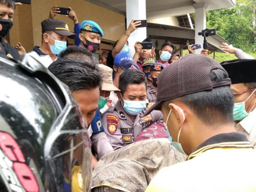 Petugas kepolisian bersama warga mengevakuasi salah satu korban longsor (Istimewa)
