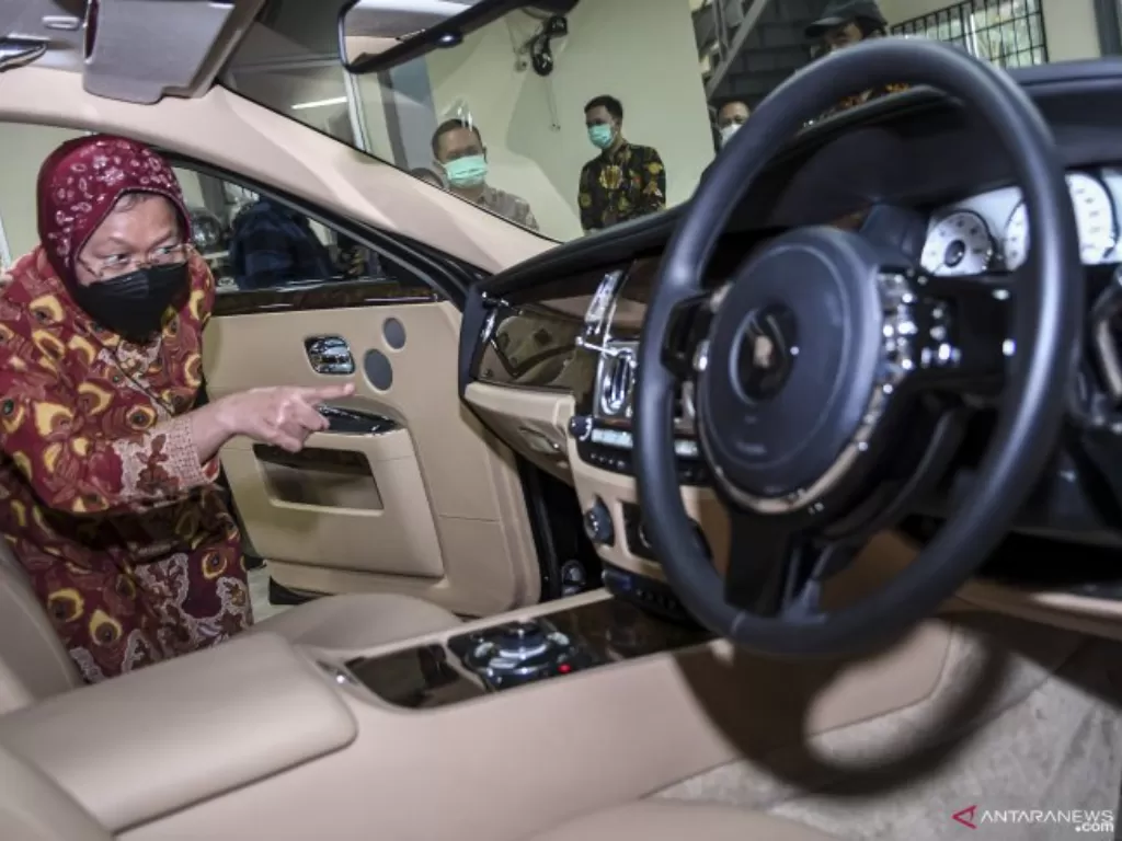 Menteri Sosial Tri Rismaharini mengamati bagian dalam mobil Rolls Royce Tipe Ghost yang merupakan barang undian di salah satu gudang Kemensos di Jakarta (ANTARA FOTO/M Risyal Hidayat/hp)