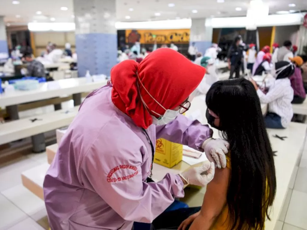 Petugas menyuntikan vaksin COVID-19 kepada pedagang di Pasar Tanah Abang Blok A, Jakarta. (ANTARAFOTO/Hafidz Mubarak A)