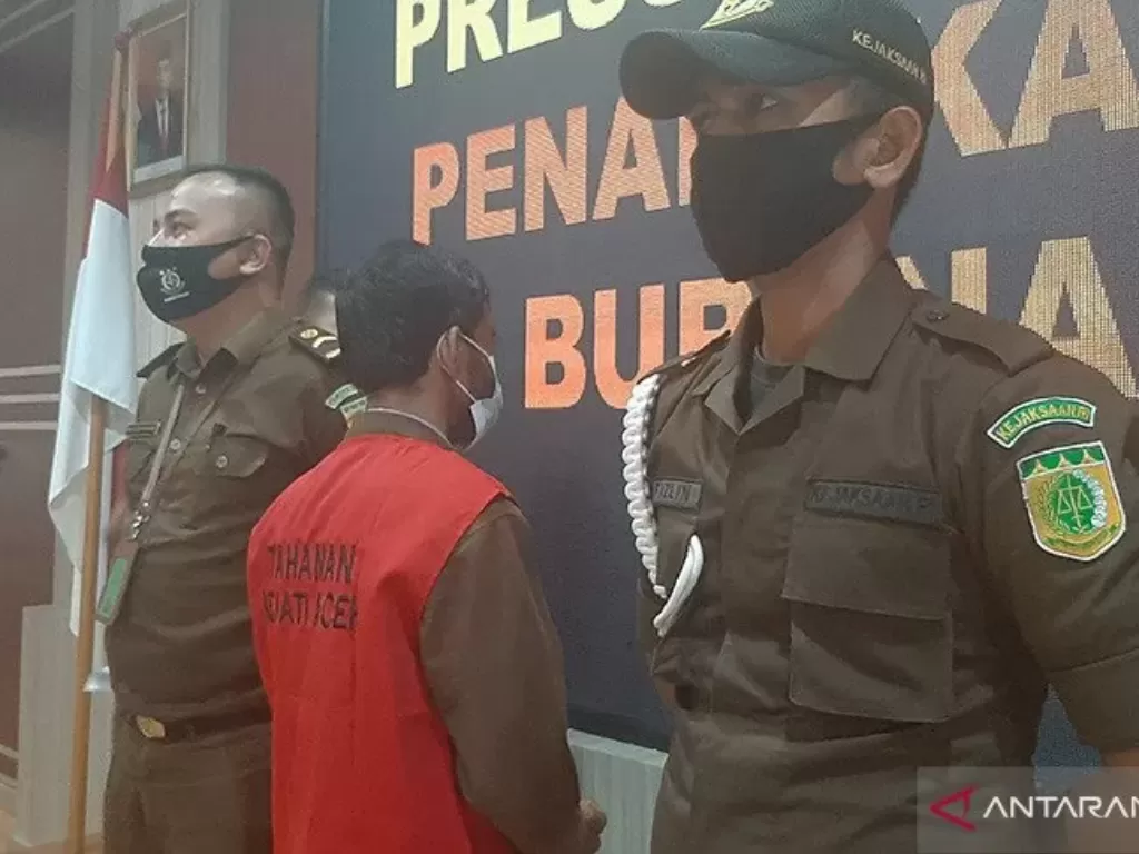 Petugas mengapit terpidana pencurian kerbau yang ditangkap Tim Tabur di Kejati Aceh, di Banda Aceh, Selasa (23/2/2021). (photo/Antara Aceh/M Haris SA)