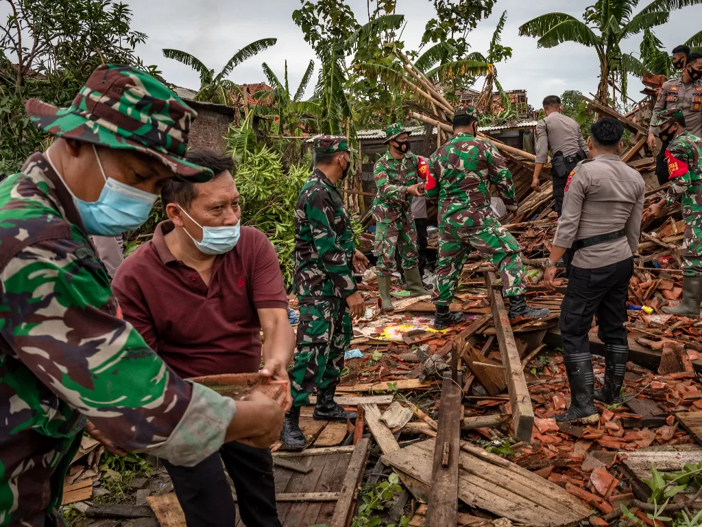 Sejumlah personel TNI-Polri dan warga bergotong royong memperbaiki rumah warga yang rusak (ANTARA FOTO/Aji Styawan)