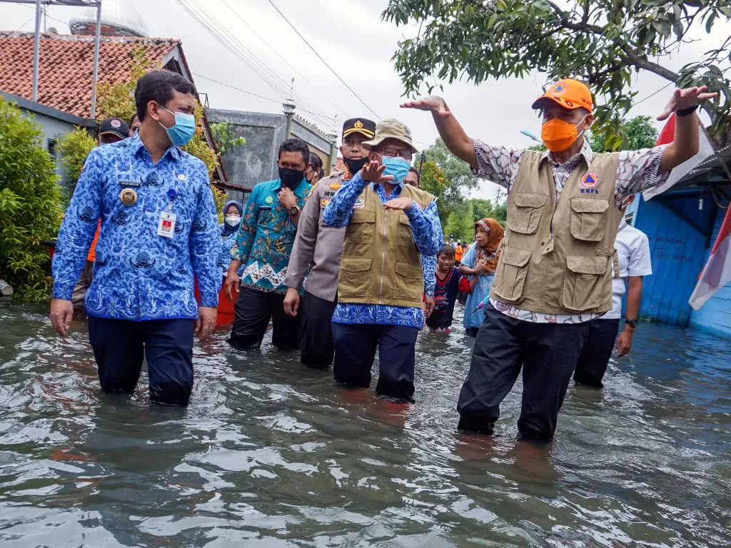 Gubernur Jawa Tengah Ganjar Pranowo (kanan) didampingi Wakil Wali Kota Pekalongan Afzan Arslan Djunaid (kiri) meninjau banjir di Pekalongan, Jawa Tengah, Rabu (17/2/2021). (photo/ANTARA FOTO/Harviyan Perdana Putra)