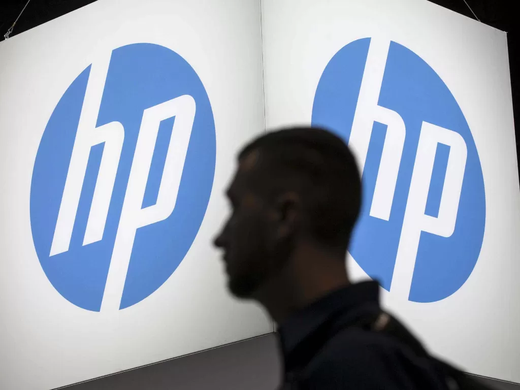 Ilustrasi seorang pria sedang berada di depan logo HP (photo/REUTERS/Jim Young)