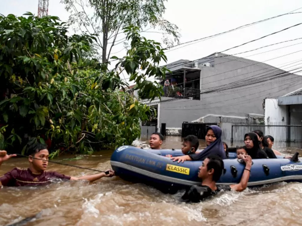 Relawan berusaha mengevakuasi warga yang terjebak banjir dengan menggunakan perahu karet di kawasan Wijaya Timur, Petogogan, Jakarta, Sabtu (20/2/2021). (ANTARA FOTO/M Risyal Hidayat)