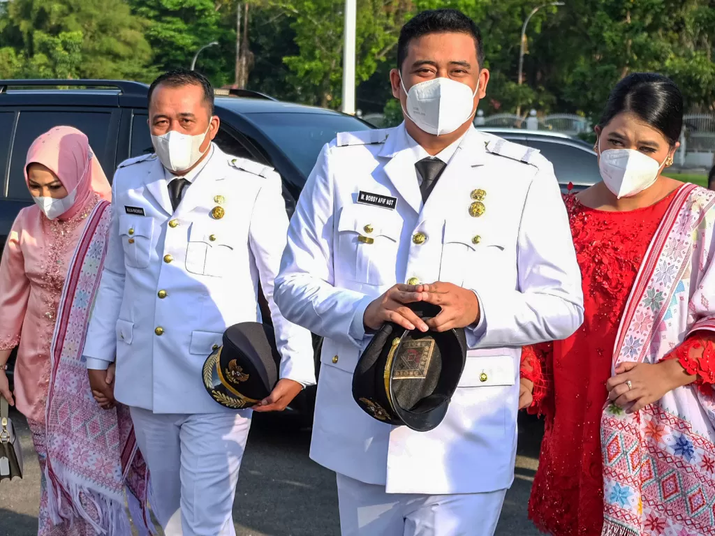Wali Kota Medan terpilih Muhammad Bobby Afif Nasution (kedua kanan) bersama Wakil Wali Kota Medan terpilih Aulia Rachman (ketiga kiri) didampingi istri mengikuti pelantikan di Medan, Sumatera Utara, Jumat (26/2). (photo/ ANTARA FOTO/Irsan Mulyadi)