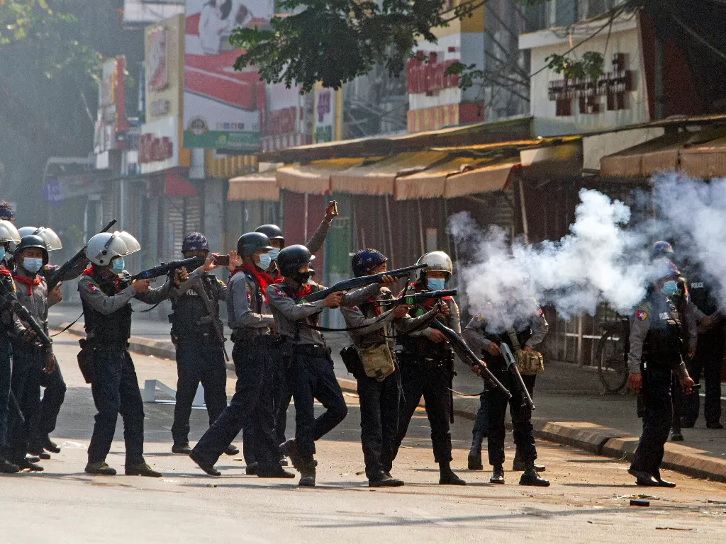  Petugas polisi anti huru hara menembakkan tabung gas air mata selama protes terhadap kudeta militer di Yangon, Myanmar, Minggu (28 /2). (photo/REUTERS/Stringer)