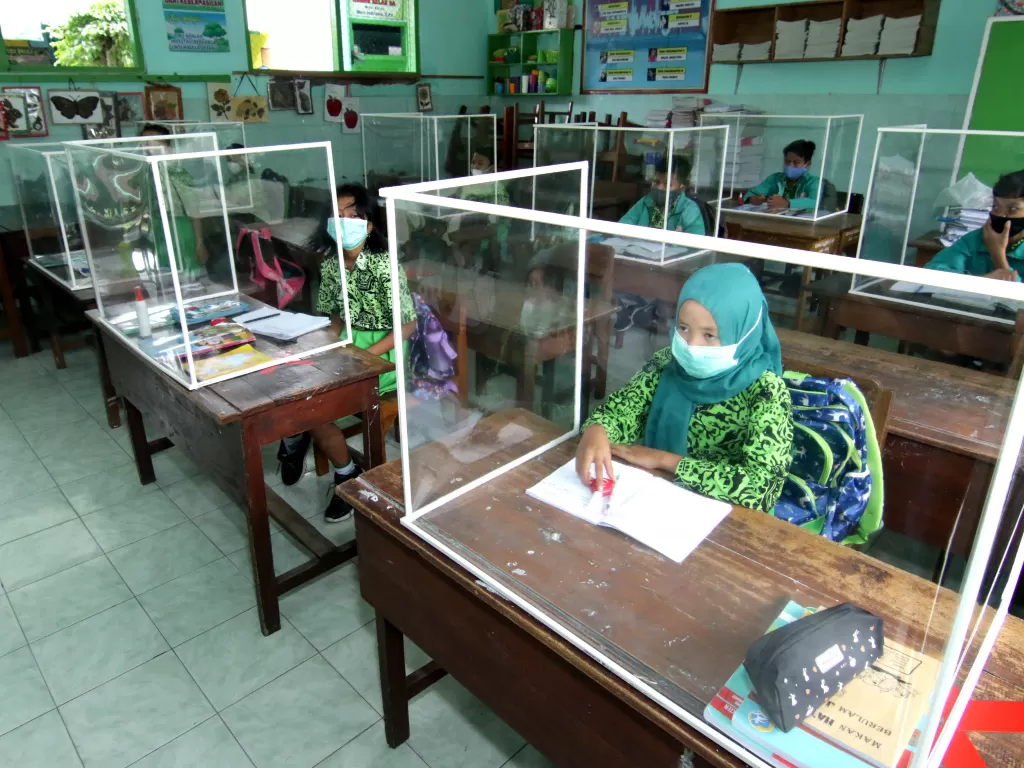 Murid mengikuti sekolah tatap muka di kelas yang dilengkapi dengan bilik plastik di SDN 1 Lateng, Banyuwangi, Jawa Timur, Rabu (24/2/2021). (ANTARA/Budi Candra Setya)