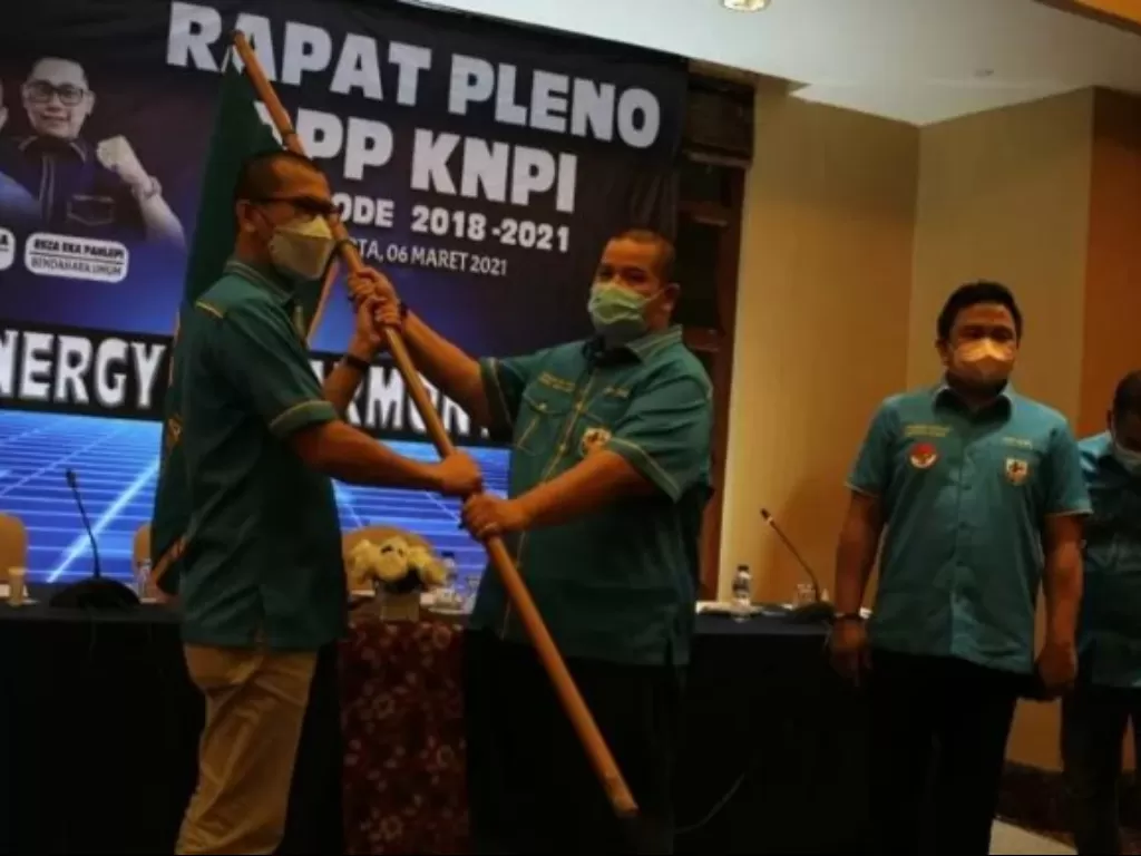 Wakil Ketua Umum DPP KNPI Ahmad Andi Bahri menyerahkan bendera pataka KNPI kepada Mustahuddin seusai rapat Rapat Pleno DPP KNPI Periode 2018-2021 di Jakarta, Sabtu (7/3/2021). (ANTARA/Humas DPP KNPI).