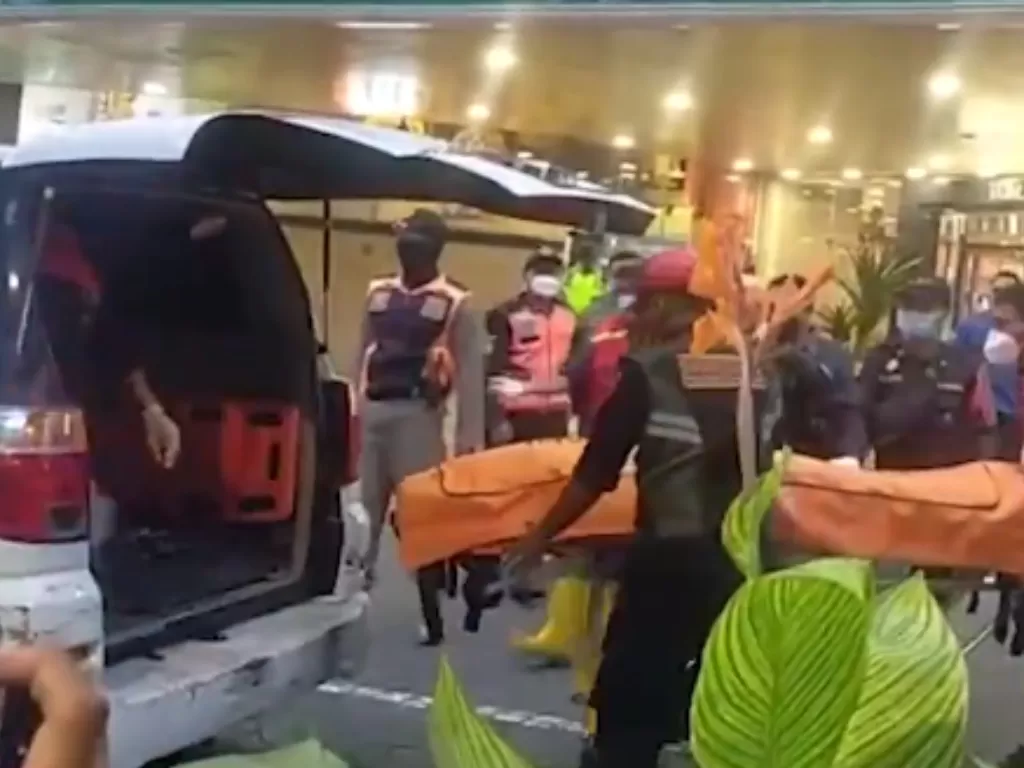 Petugas mengevakuasi jenazah pria yang jatuh dati lantai 2 mal di Surabaya. (Istimewa)