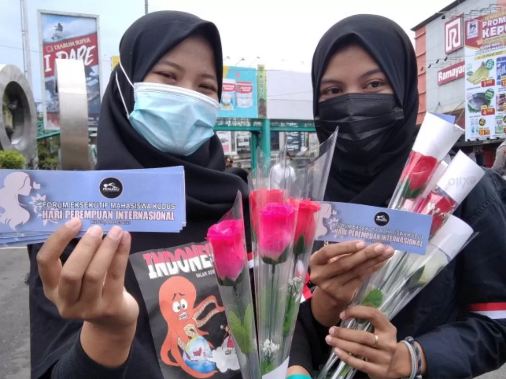 Peserta aksi damai menunjukkan bunga yang hendak dibagikan kepada masyarakat saat menggelar aksi damai menuntut disahkannya RUU PKS di Alun-alun Kudus, Jawa Tengah, Senin (8/3/2021). (ANTARA/Akhmad Nazaruddin Lathif)