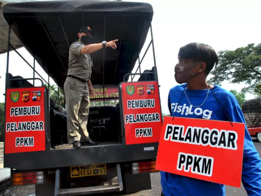 Anggota Satpol PP Kota Bogor menghukum warga yang tidak memakai masker saat razia penegakan PPKM di Jalan Bogor Nirwana Residence (BNR), Mulyaharja, Kota Bogor, Jawa Barat, Senin (15/2/2021).(ANTARA FOTO/Arif Firmansyah)