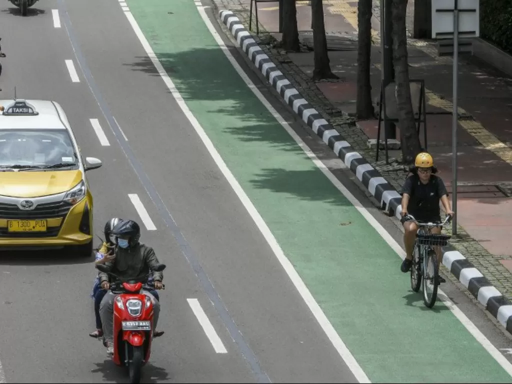  Pesepeda melintasi jalur sepeda di Jalan MH Thamrin, Jakarta, Sabtu (6/2/2021). (ANTARA FOTO/Galih Pradipta)