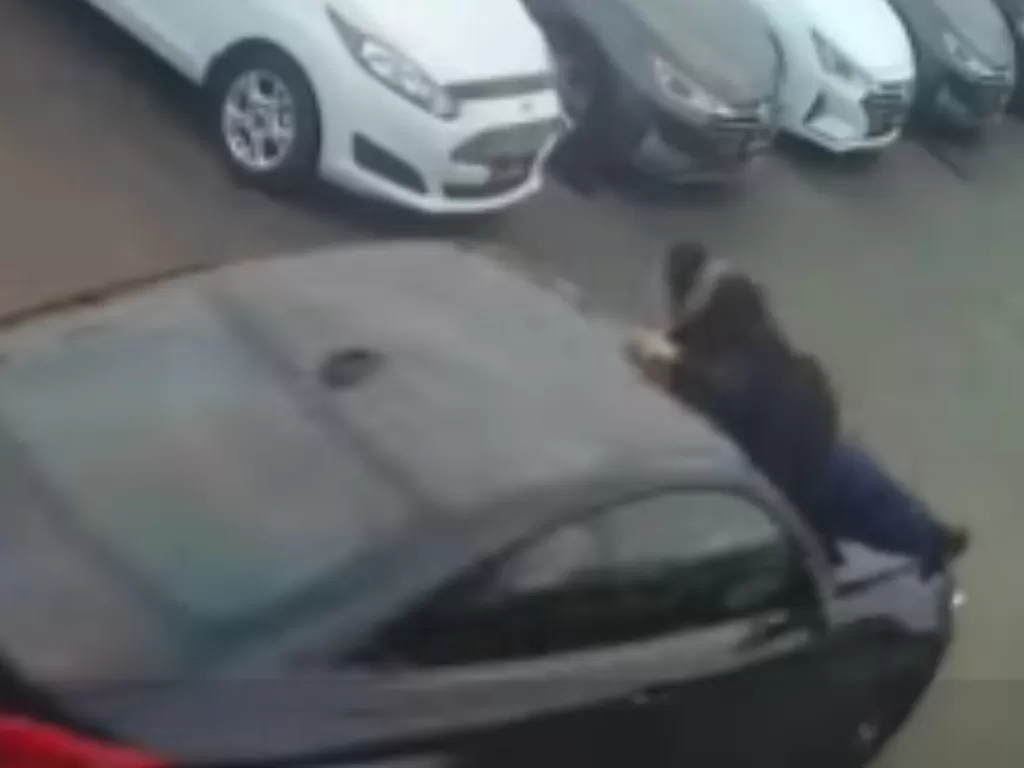 Tampilan penjual yang gelantung di kap mesin BMW M4 yang dicuri. (photo/SS/Facebook/Sport Motors)