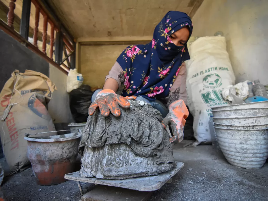 Nuraini (32) mencetak sampah popok bayi yang telah dibasahi dengan adonan semen (ANTARA FOTO/Ahmad Subaidi)
